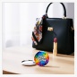 Preview: 56 mm Button Taschenspiegel mit individuellem Fotodruck vor einer offenen Handtasche