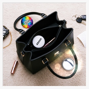 44 mm Button Taschenspiegel mit individuellem Fotodruck vor einer Handtasche