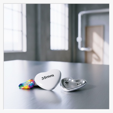 Detailansicht der Sicherheitsnadel-Befestigung am Gehäuse des kleinen Herz-Buttons.