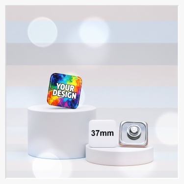 Ein quadratischer 37x37 mm Button, der per Magnet sicher und ohne Löcher an einem modernen Sakko befestigen lässt.